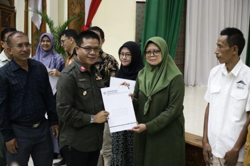 Bupati Bandung Dadang Supriatna saat memberikan sertifikat halal kepada pelaku usaha mikro, kecil, dan menengah (UMKM) di Kabupaten Bandung, Jawa Barat, Selasa (9/1/2024). 