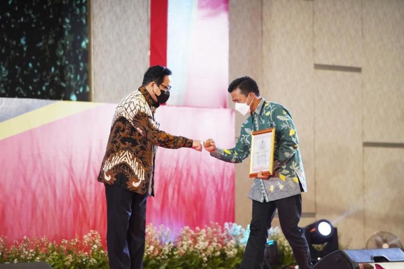 Bupati Bandung HM Dadang Supriatna (kanan) menerima piagam penghargaan Anugerah Meritokrasi ASN dari Ketua Komisi Aparatur Sipil Negara (KASN) Agus Pramusinto di Grand Ballroom The Westin, Surabaya, Selasa (7 /12). 