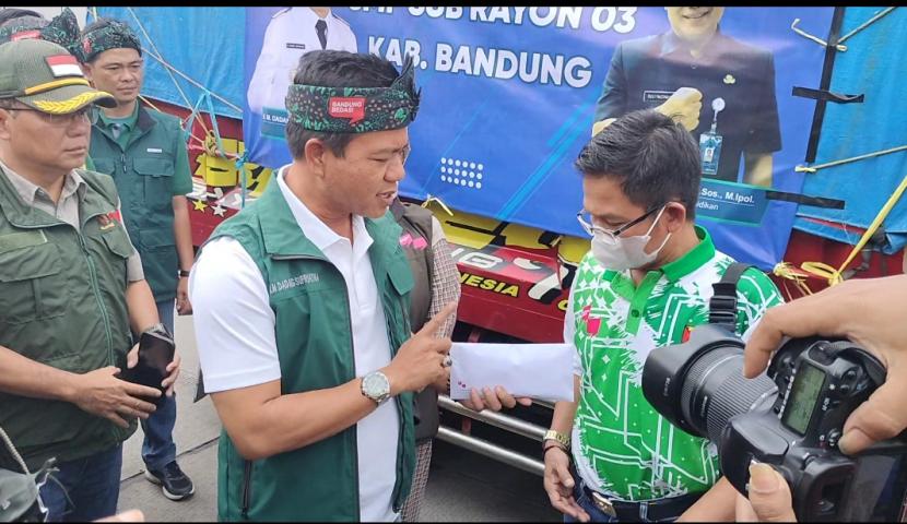 Bupati Bandung HM Dadang Supriatna saat menyerahkan bantuan uang dan bahan pokok kepada korban gempa Cianjur.
