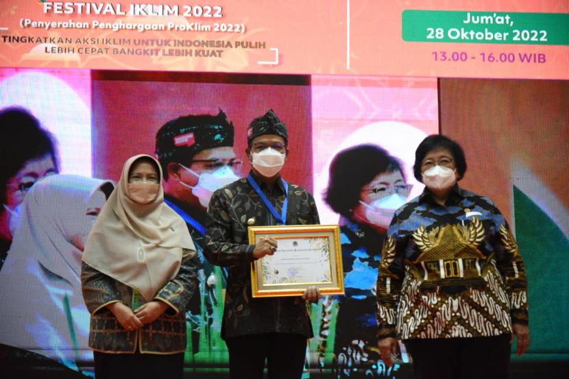 Bupati Bandung HM Dadang Supriatna (tengah) menunjukkan piagam penghargaan Program Kampung Iklim (ProKlim) dari Menteri Lingkungan Hidup dan Kehutanan RI Siti Nurbaya (kanan) di Jakarta, Jumat (28/10).