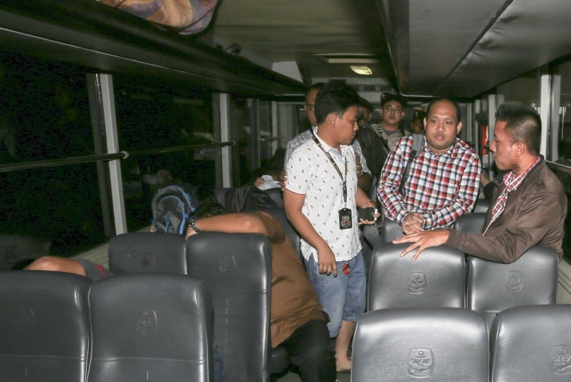 Bupati Banyuasin Yan Anton Ferdian (tengah) dijaga petugas kepolisian saat berada di dalam kendaraan di Polda Sumsel, Palembang, Sumatra Selatan, Minggu (4/9). 