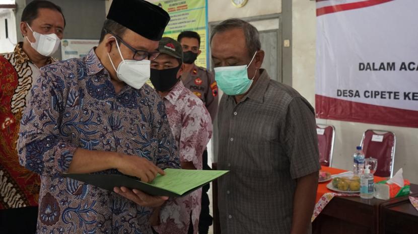 Bupati Banyumas, Ir Achmad Husein menyerahkan secara simbolis sertifikat tanah kepada warga masyarakat Desa Cipete, Kecamatan Cilongok, Kamis (14/07/2022). 