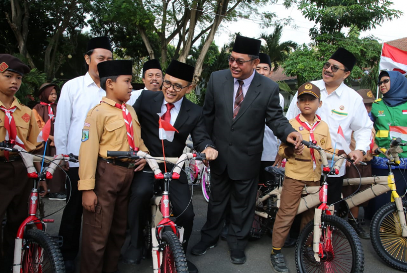 Bupati Banyuwangi Abdullah Azwar Anas menyerahkan sepeda angin untuk siswa kurang mampu.