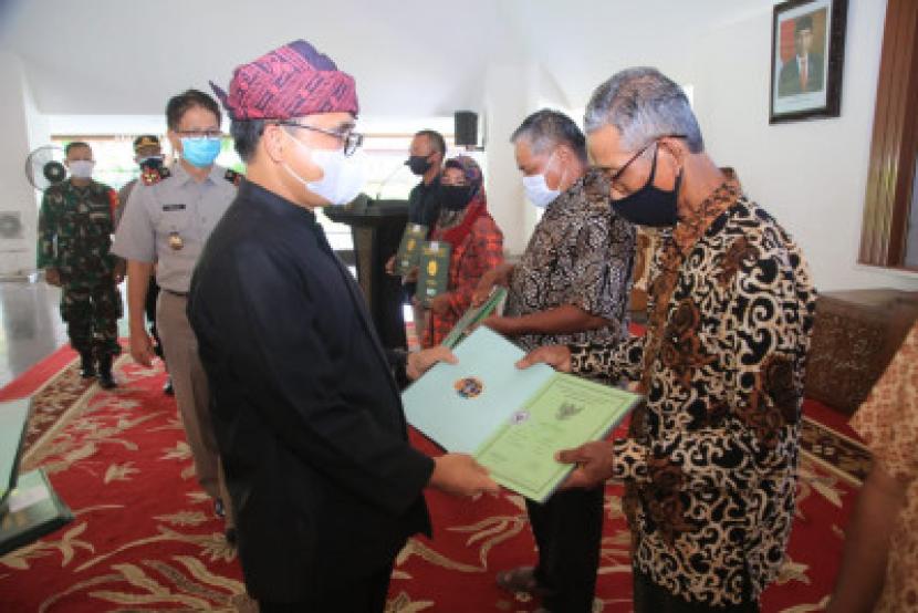 Bupati Banyuwangi Abdullah Azwar Anas menyerahkan sertifikat Pendaftaran Tanah Sistematik Lengkap (PTSL) kepada 2.065 warga, Selasa (5/1).