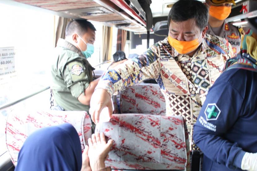 Bupati Garut Rudy Gunawan memeriksa suhu tubuh dan membagikan hand sanitizer ke para pengemudi dan penumpang kendaraan yang masuk ke Garut, Ahad (22/3).