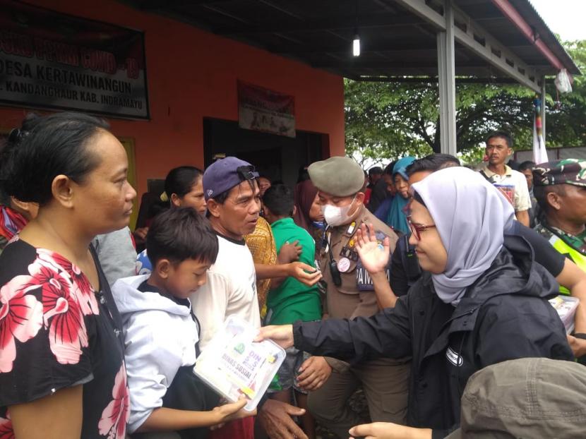 Bupati Indramayu, Nina Agustina, memberikan bantuan kepada para warga terdampak banjir akibat gelombang tinggi dan hujan lebat di Desa Eretan Kulon, Kecamatan Kandanghaur, Kabupaten Indramayu, Ahad (1/1/20223). Ratusan warga mengungsi di Balai Desa Kertawinangun, Kecamatan Kandanghaur.