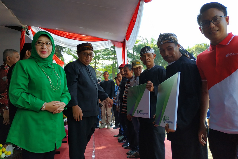 Bupati kabupaten sukabumi marwan hamami menyerahkan kartu tanda peserta bpjs kepada para nelayan di palabuhanratu. 