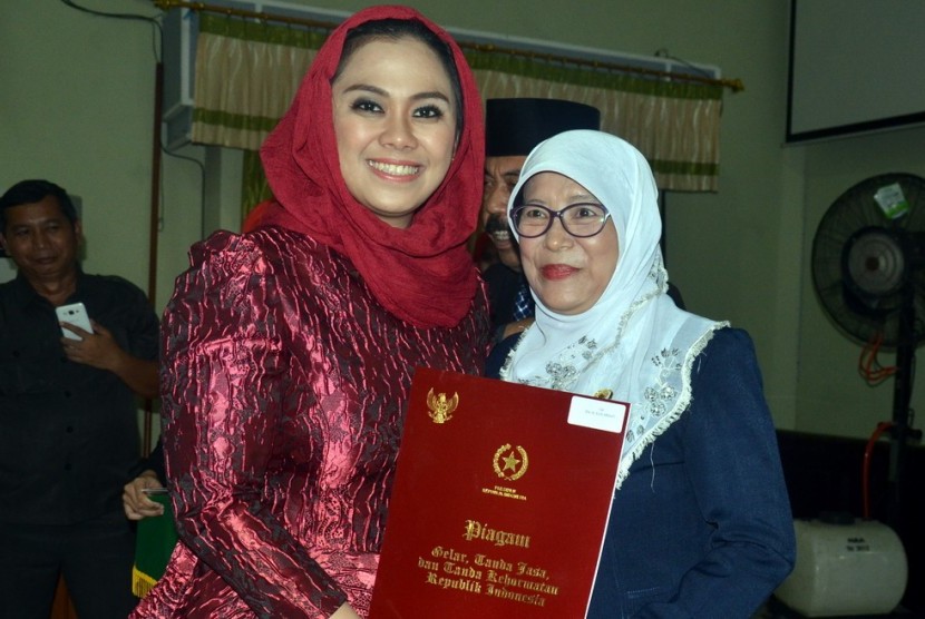 Bupati Karawang, dr.Cellica Nurrachadiana saat menyerahkan penghargaan tanda kehormatan Satya Lancana Karya Satya Presiden Republik Indonesia di Karawang beberapa waktu lalu.