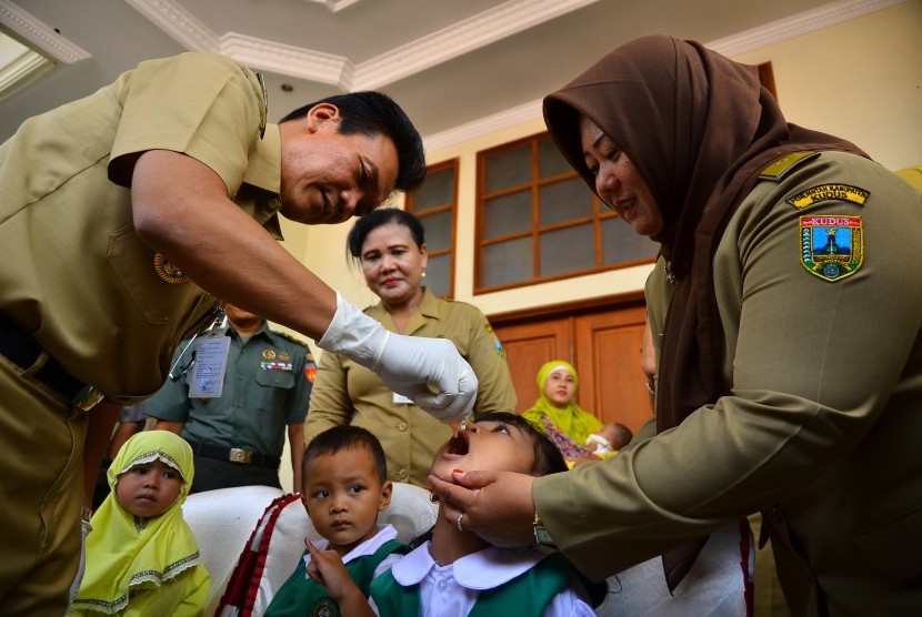 Bupati Kudus Mustofa (kiri) meneteskan vaksin polio kepada anak saat peresmian Pekan Imunisasi Nasional (PIN) Polio 2016 di Desa Gondang Manis, Kudus, Jawa Tengah (14/3).