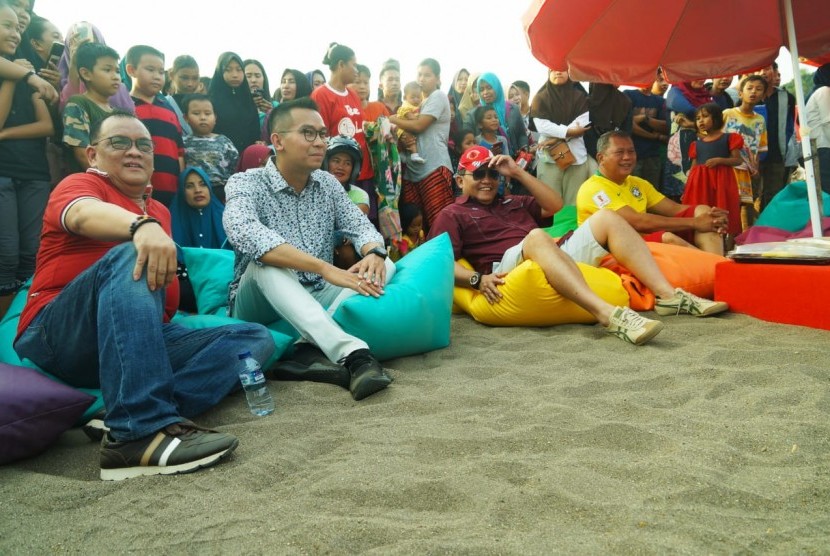 Bupati Muba Dodi Reza memakai pakaian santai bak berada di area pantai sambil menikmati kegiatan kreatif yang disajikan oleh Dinas Pemuda Olahraga dan Pariwisata Muba.