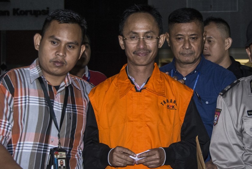 Bupati Pamekasan Achmad Syafii (kedua kiri) dengan mengunakan rompi tahanan KPK bergegas seusai diperiksa di gedung KPK, Jakarta, Kamis (3/8). 