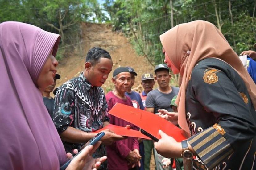Bupati Purbalingga Dyah Hayuning Pratiwi menyerahkan bantuan untuk keluarga terdampak bencana longsor di Desa Kaliori, Kecamatan Karanganyar, Kabupaten Purbalingga, Jawa Tengah, Jumat (19/4/2024). 