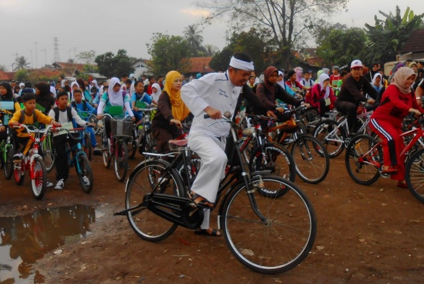Bupati Purwakarta Dedi Mulyadi bersepeda bersama ratusan siswa siswi baru SMP Negeri 1 Purwakarta, Kamis (23/7). Dedi mengajak seluruh siswa siswi di Purwakarta menggunakan transportasi sepeda ke sekolah. Foto: Rachmat Santosa Basarah 