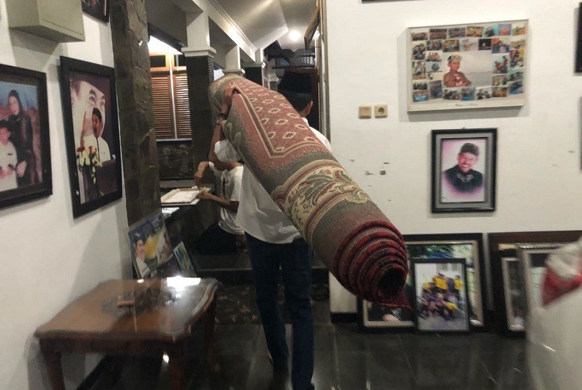 Bupati Purwakarta Dedi Mulyadi, memanggul karpet untuk dipindahkan dari rumah dinas ke kediaman pribadinya, Sabtu malam (20/1). 