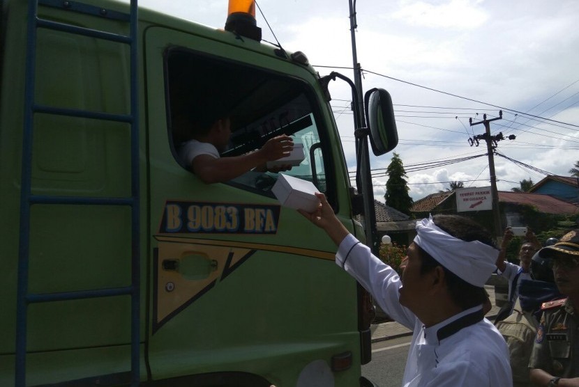 Bupati Purwakarta, Dedi Mulyadi membagikan makanan kepada para pengendara yang terjebak macet di Tol Cipularang menyusul adanya perbaikan Jembatan Cisomang, Kamis (29/12).