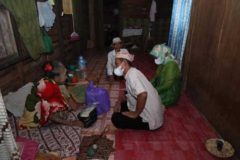 Bupati Tanah Laut, H. Sukamta (baju putih) mengunjungi sejumlah warga kurang mampu saat malam takbiran.