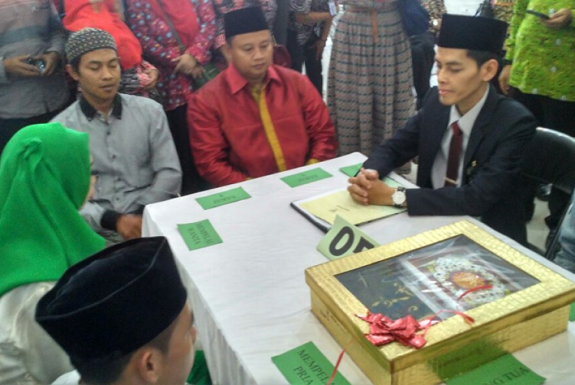 Bupati Tasikmalaya Uu Ruzhanul Ulum (kemeja merah) menjadi saksi dalam gelaran nikah massal di gedung Islamic Center, Kabupaten Tasikmalaya, Jawa Barat, Jumat (9/2). 