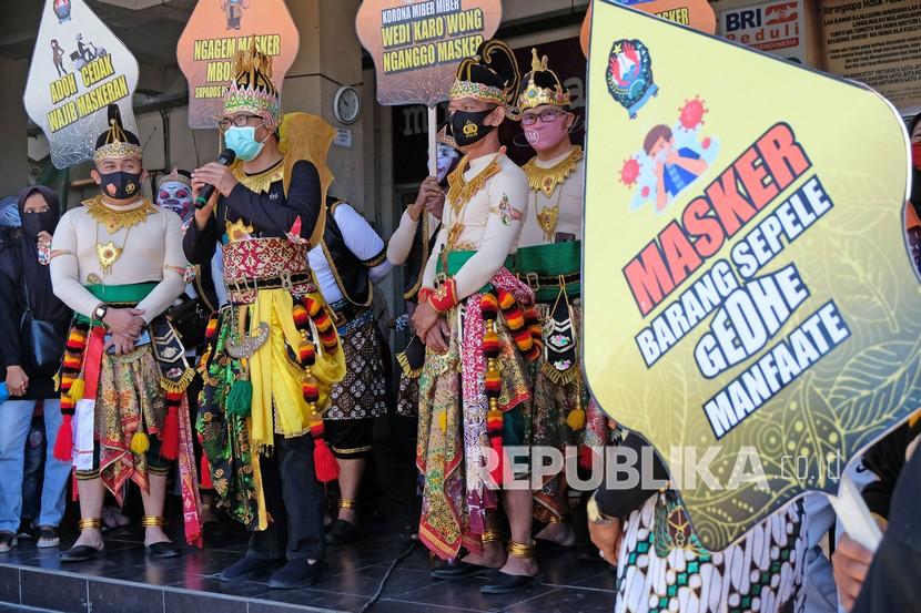 Bupati Temanggung M Al Khadziq berpakaian tokoh pewayangan Prabu Kresna (tengah) menyampaikan pidato saat sosialisasi gerakan 3M (memakai masker, mencuci tangan, dan menjaga jarak) di Pasar Legi Parakan, Temanggung, Jawa Tengah, Ahad (6/9/2020). Awal pekan ini Kabupaten Temanggung sudah masuk zona oranye.