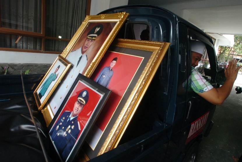 Bupati terpilih Uu Ruzhanul Ulum (kanan), mengangkut pakaian dan foto dirinya yang disimpan di Pendopo Lama Kabupaten Tasikmalaya, Jawa Barat, Senin (7/3). 