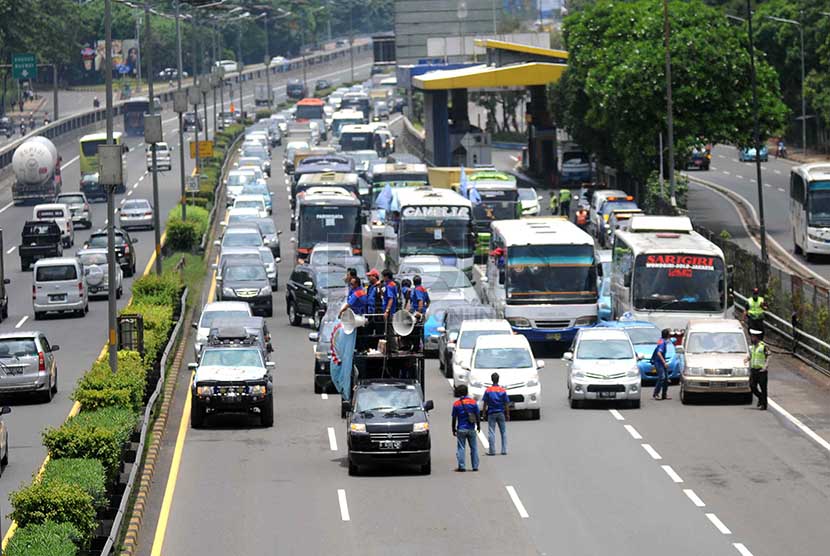 Buruh berorasi di tengah jalan tol dan membuat macet sebentar di depan Gedung DPR Senayan, Jakarta, Selasa (25/2).      (Republika/Wihdan)