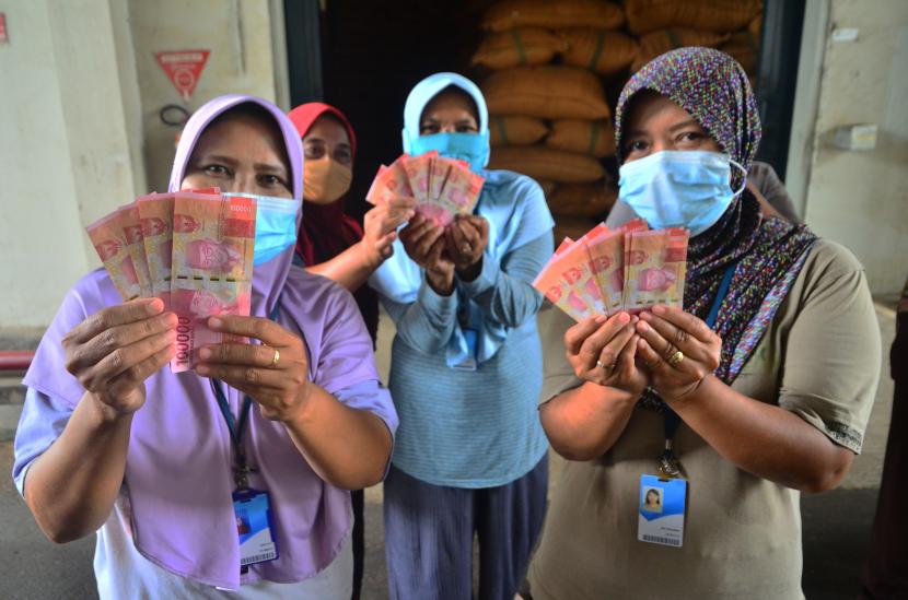 Buruh rokok menunjukkan uang yang diterimanya saat pembagian Bantuan Langsung Tunai (BLT) di Kudus, Jawa Tengah, Rabu (15/12/2021). 