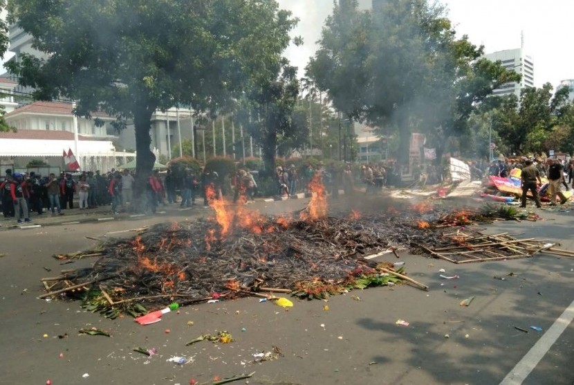 Buruh yang tergabung dalam LSP LEM SPSI membakar puluhan karangan bunga di depan Balai Kota DKI Jakarta, Jakarta Pusat, Senin (1/5). 