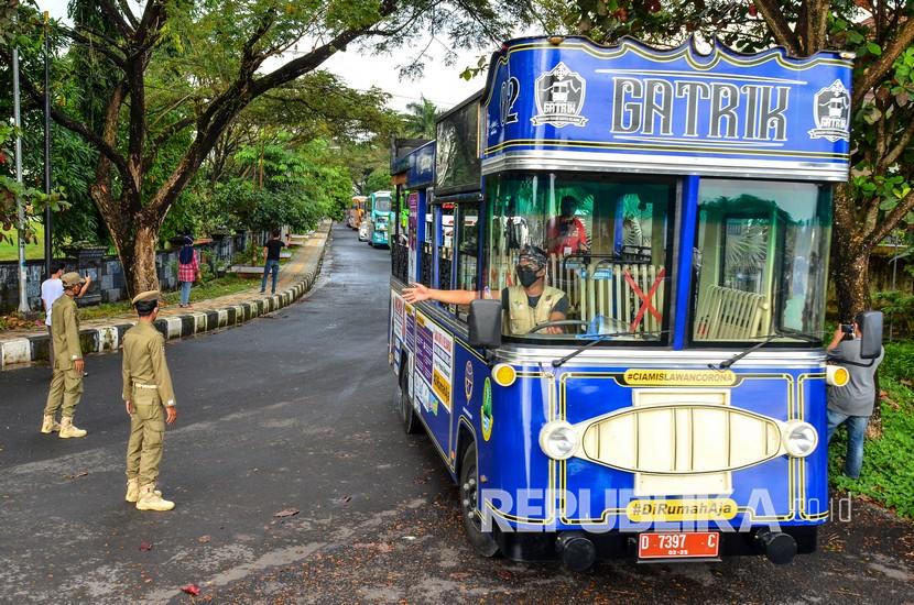 Bus pariwisata parkir di Kawasan Kantor Tourism Information Center (TIC) saat pelepasan konvoi bus di Kabupaten Ciamis, Jawa Barat, Sabtu (11/7/2020). Sebanyak 24 bus pariwisata yang tergabung dalam Ikatan Perusahaan Otobus Priangan timur (IPOTI) melakukan konvoi dari Tasikmalaya menuju Pangandaran untuk mempromosikan pariwisata di Jabar setelah memasuki era normal baru dengan tetap menerapkan protokol kesehatan.
