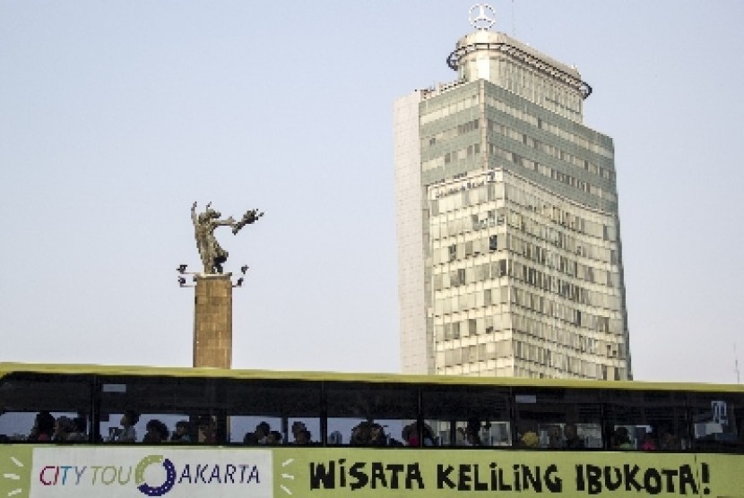   Bus tingkat wisata Jakarta melintas di sekitar Bundaran HI, Jakarta Pusat