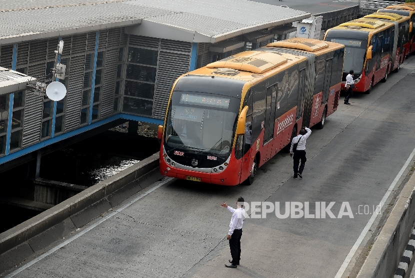  Bus Transjakarta menaikan dan menurunkan penumpang di Halte Harmoni, Jakarta, Senin(1/5).