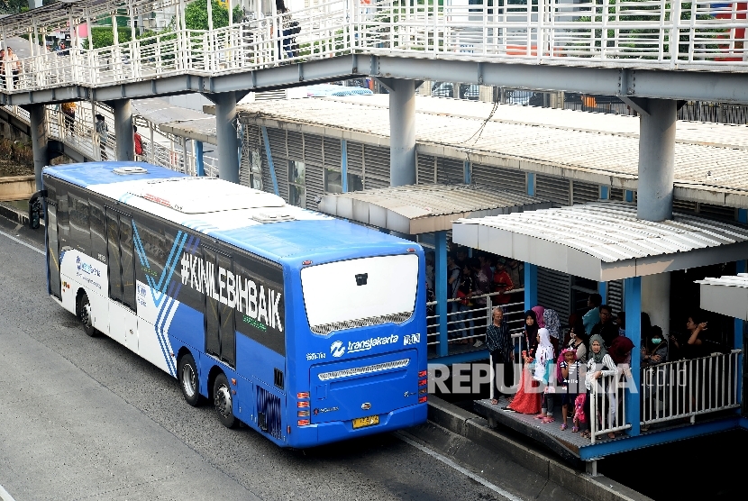 Bus Transjakarta menaikan dan menurunkan penumpang di Halte Harmoni, Jakarta, Senin(1/5).