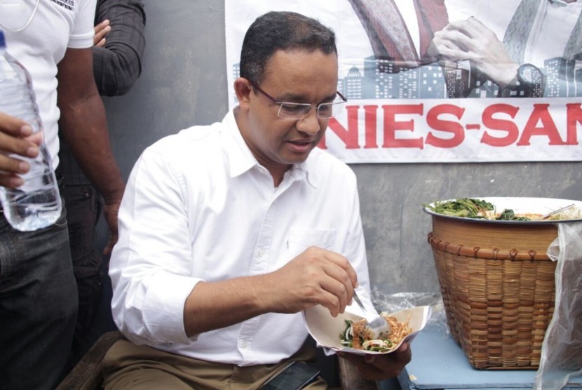 Cagub DKI Jakarta, Anies Baswedan, mencicipi pecel legendaris Sayijatinah (53) atau Bukde Tin saat blusukkan ke Pulogadung, Jakarta Timur, Selasa (10/1). 