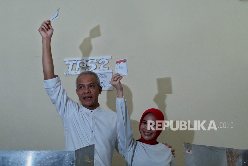 Cagub Jateng nomor urut 1 Ganjar Pranowo (kiri) bersama istri Siti Atiqoh, memperlihatkan surat suara Pemilihan Gubernur dan Wakil Gubernur Jawa Tengah, di tempat pemungutan suara (TPS) 2, Kelurahan Gajahmungkur, Semarang, Jawa Tengah, Rabu (27/6).