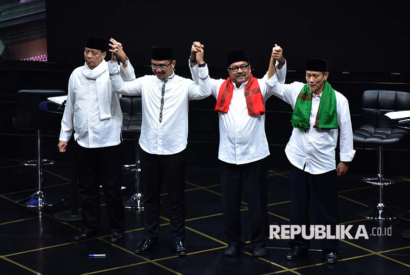 Calon Gubernur dan Wakil Gubernur Banten nomor urut satu Wahidin Halim (kiri) dan Andika Hazrumy (kedua kiri) bersama cagub nomor urut dua Rano Karno (kedua kanan) dan Embay Mulya Syarief mengangkat tangan usai mengakhiri sesi debat publik.