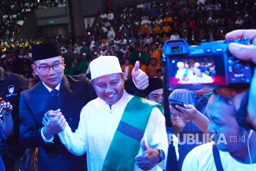 Calon Gubernur dan Wakil Gubernur Jabar Ridwan Kamil dan UU berfoto bersama dengan simpatisan yang hadir pada Rapat Akbar Keluarga Rindu Jabar Juara, di Gedung Sabuga, Kota Bandung, Kamis (8/2) malam.