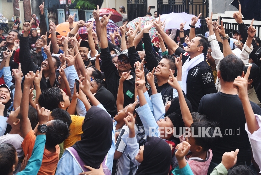 Calon Gubernur DKI Jakarta Agus Harimurti Yudhoyono (kanan) bersama pendukungnya mengacungkan angka satu saat berkampanye di Cidodol, Kebayoran Lama, Jakarta, Jumat (3/2). 