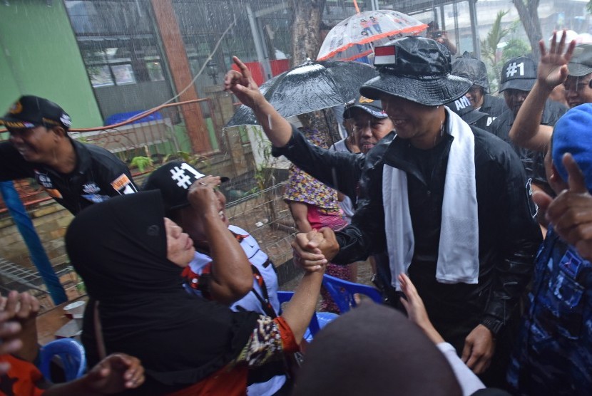 Calon Gubernur DKI Jakarta Agus Harimurti Yudhoyono (kanan) menyapa warga ketika mengunjungi Kompleks UKA, Tugu Utara, Jakarta, Senin (16/1).