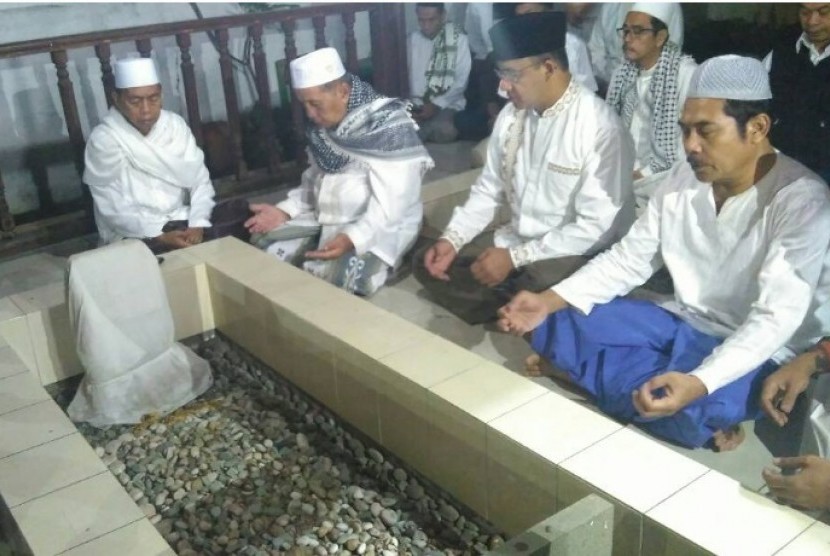 Calon gubernur DKI Jakarta Anies Baswedan (kedua kanan) mengawali hari pemungutan suara dengan Subuh berjamaah dan berziarah ke makam sesepuh kampung tempatnya tinggal di Lebak Bulus Dalam, Cilandak, Jakarta Selatan, Rabu (19/4).  