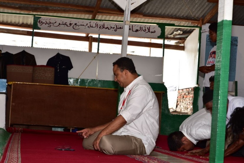 Calon Gubernur DKI Jakarta Anies Baswedan menunaikan shalat di masjid yang masih berdiri di tengah reruntuhan kawasan yang digusur di Kampung Akuarium, Selasa (7/2) pagi.