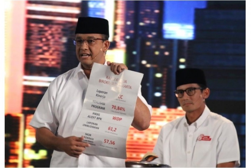 Calon Gubernur DKI Jakarta Anies Baswedan menunjukkan kertas yang berisi catatan mengenai buruknya pencapaian birokrasi di Jakarta dalam debat kandidat kedua di Jakarta, Jumat (27/1).