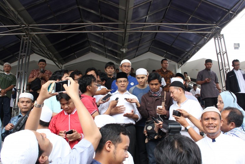 Calon Gubernur DKI Jakarta Anies Baswedan (tengah) menjawab pertanyaan wartawan seusai bersilaturahmi dengan jemaah di Mesjid Al-Ittihad, Jakarta, Jumat (28/10).