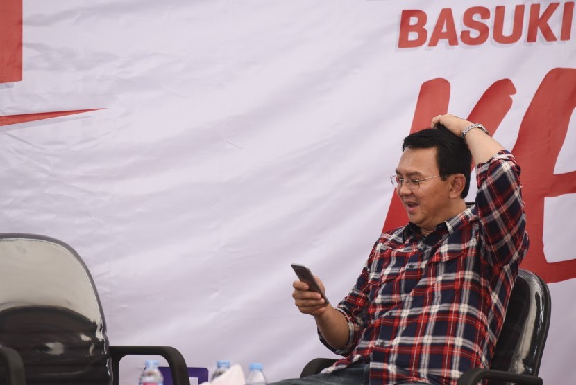 Calon Gubernur DKI Jakarta Basuki Tjahaja Purnama atau Ahok memainkan telepon selularnya saat menerima pengaduan warga di Rumah Lembang, Jakarta, Rabu (16/11). 