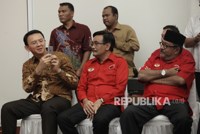 Calon Gubernur DKI Jakarta Basuki Tjahaja Purnama (kiri) memotret Calon Wakil Gubernur DKI Jakarta Djarot Syaiful Hidayat (tengah) dan Calon Gubernur Banten Rano Karno (kanan) sebelum menandatangani kontrak saat deklarasi Pasangan Calon PDI Perjuangan di K