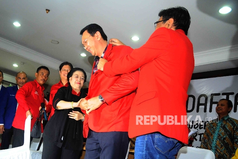 Calon gubernur DKI Jakarta Basuki Tjahaja Purnama mengenakan jaket pertai secara simbolis didampingi wakil gubernur Djarot Saifut Hidayat dan Ketua Umum PDIP Megawati Soekarnoputri saat mendaftar sebagai Pasangan calon gubernur dan wakil gubernur DKI Jakar