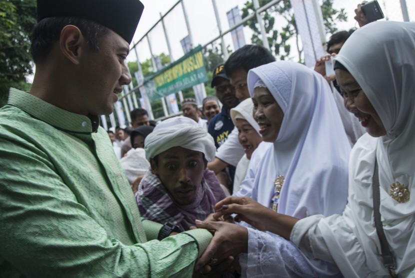 Calon Gubernur DKI Jakarta nomer urut satu Agus Harimurti Yudhoyono (kiri) menyalami warga saat menghadiri Tablig Akbar dan Istighatsah di Lapangan Blok S, Jakarta, Kamis (9/2). 