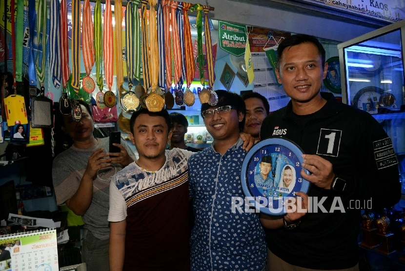 Calon Gubernur DKI Jakarta nomor urut 1 Agus Harimurti Yudhoyono (AHY) berfoto dengan pedagang ketika kampanye blusukan di Pasar Senen, Jakarta, Selasa (12/11). 