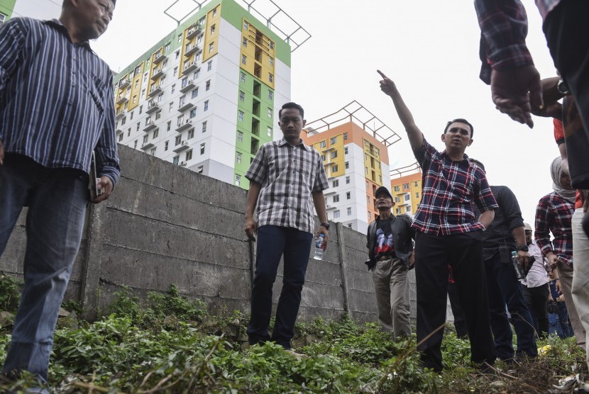  Calon Gubernur DKI Jakarta Basuki Tjahaja Purnama atau Ahok menunjuk tower apartemen yang dibangun dekat dengan tiang SUTET (Saluran Udara Tegangan Ekstra Tinggi) saat blusukan ke Kelurahan Jatinegara, Cakung, Jakarta, Senin (6/2).