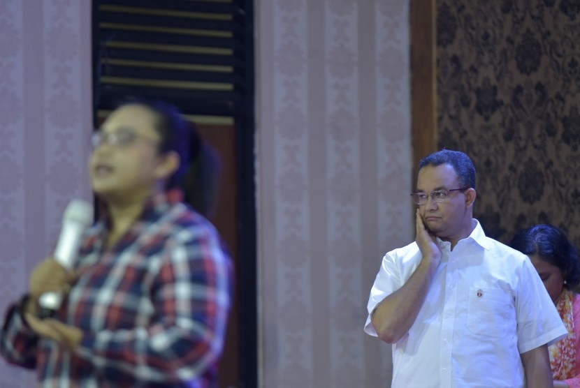 Calon gubernur DKI Jakarta nomor urut tiga, Anies Baswedan (kanan) menyimak paparan timses Ahok-Djarot ketika menghadiri Festival Budaya Perempuan 1001 Cerita Perempuan Kali Ciliwung di GOR Otista, Jakarta, Kamis (8/12). 