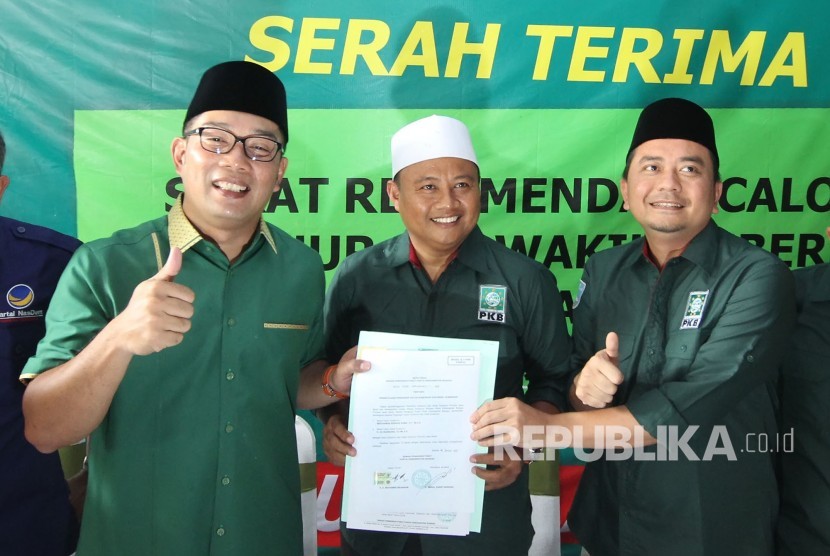 Calon Gubernur Jabar Ridwan Kamil (kiri) dan Wakilnya Uu Ruzhanul Ulum (tengah) didampingi ketua DPW PKB Jabar Syaiful Huda (kanan) memegang surat rekomendasi dukungan untuk maju di Pilgub Jabar 2018, di Kantor DPW PKB Jabar, Kota Bandung, Senin (8/10).