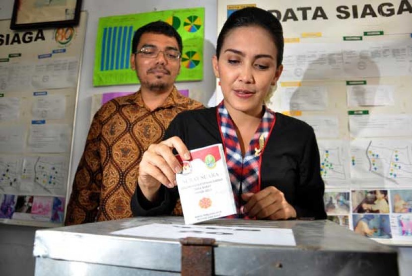  Calon Gubernur Jawa Barat Rieke Diah Pitaloka di dampingi oleh suaminya usai menggunakan hak pilihnya di TPS 20 Kukusan, Beji, Depok, Jawa Barat, Ahad (24/2). 