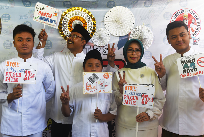 Calon Gubernur Jawa Timur Saifullah Yusuf (kedua kiri) bersama istri Fatma Saifullah Yusuf (kedua kanan) dan anak-anak berpose dengan atribut yang disediakan di tempat pemungutan suara (TPS) 3 di Gayungan, Surabaya, Jawa Timur, Rabu (27/6). 